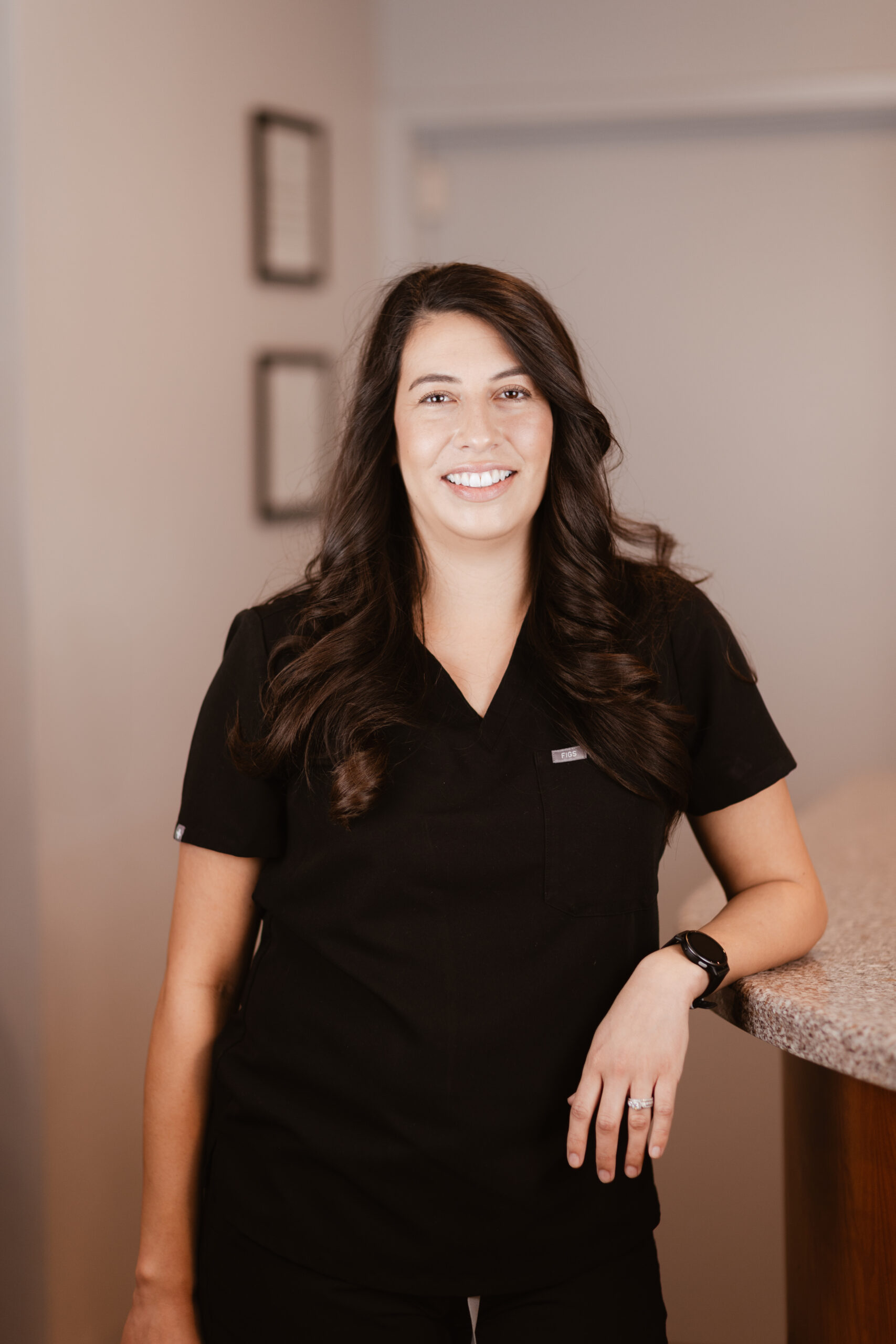 Headshot of Amanda, Registered Dental Hygienist at Centerpoint Dental in Yucaipa, CA, smiling and wearing black scrubs at the front desk