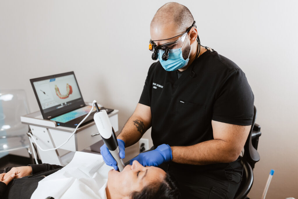 Dr. Fadi Demian, DMD, conducts a dental exam using advanced scanning technology while a 3D image of the patient’s teeth displays on a laptop at Centerpoint Dental.