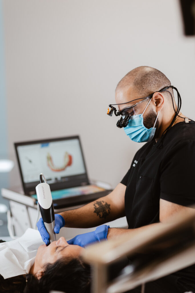 Dr. Fadi Demian, D.D.S., performing a dental procedure on a patient at Centerpoint Dental in Yucaipa, CA, wearing magnifying loupes and gloves