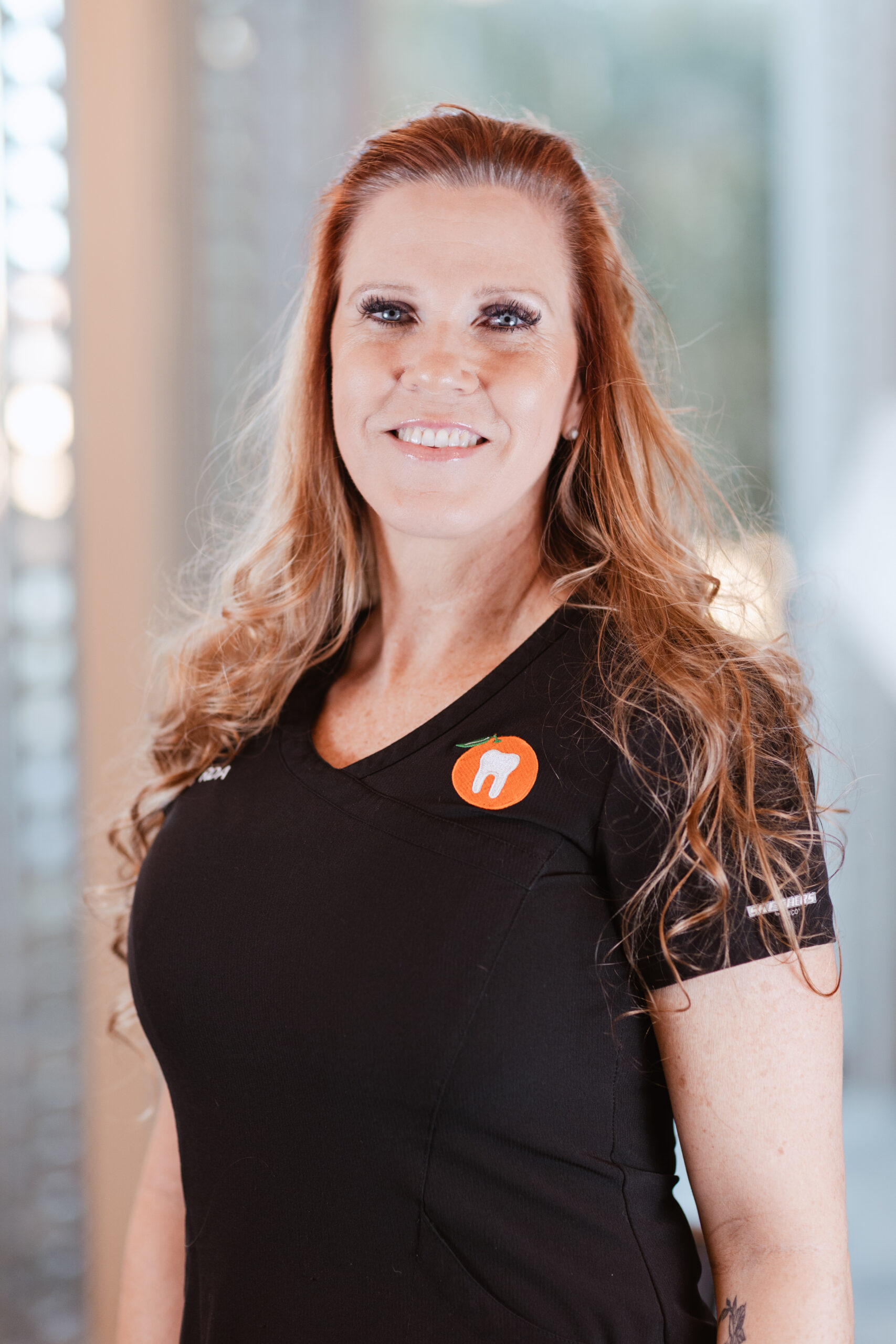 Headshot of Melanie, Registered Dental Assistant at Centerpoint Dental in Yucaipa, California, smiling in black scrubs with a tooth logo